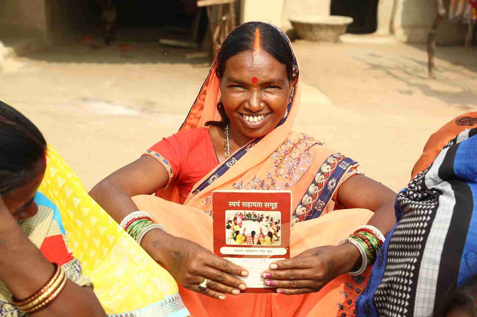 Rural woman holding a self-help group booklet